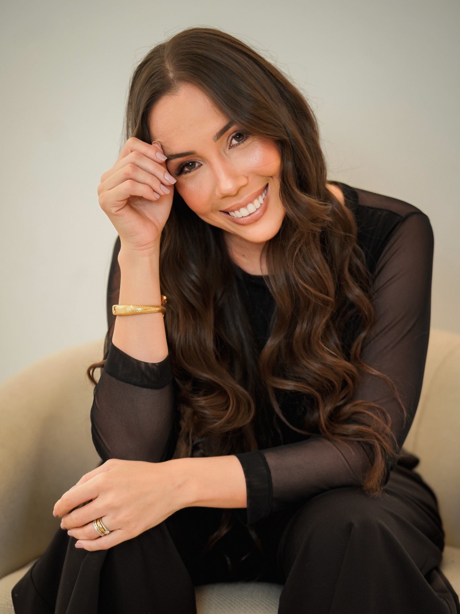 Pauline Di Paula, sorrindo, em retrato de estúdio com fundo claro